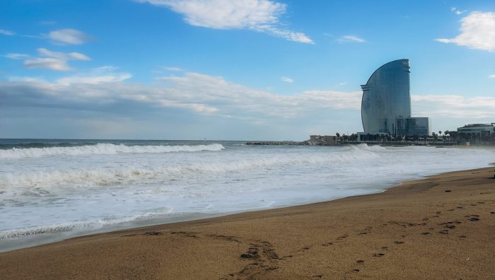 Barceloneta Beach in Barcelona with colorful sky at sunrise. Seafront, beach,coast in Spain. Suburb of Barcelona, Catalonia. Europe tourism, modern city life, or business finance and economy concept. High quality photo