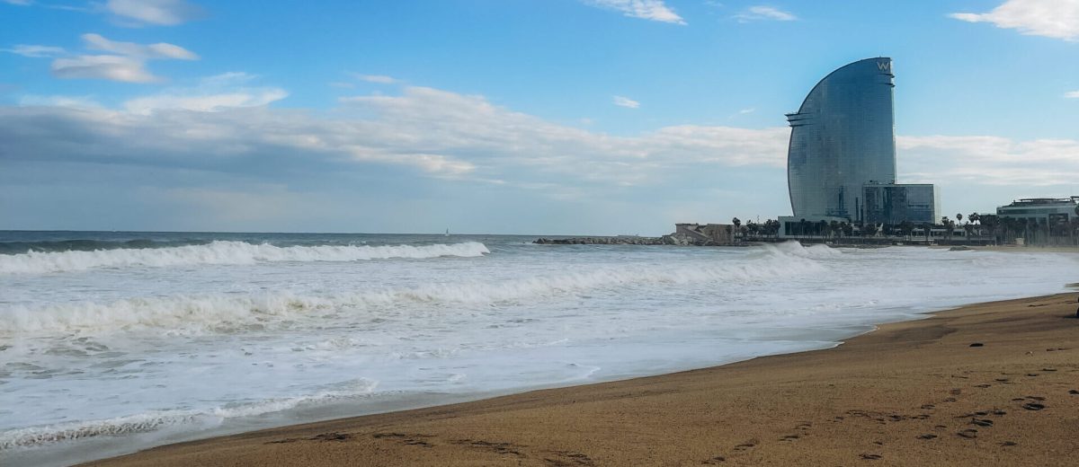 Barceloneta Beach in Barcelona with colorful sky at sunrise. Seafront, beach,coast in Spain. Suburb of Barcelona, Catalonia. Europe tourism, modern city life, or business finance and economy concept. High quality photo